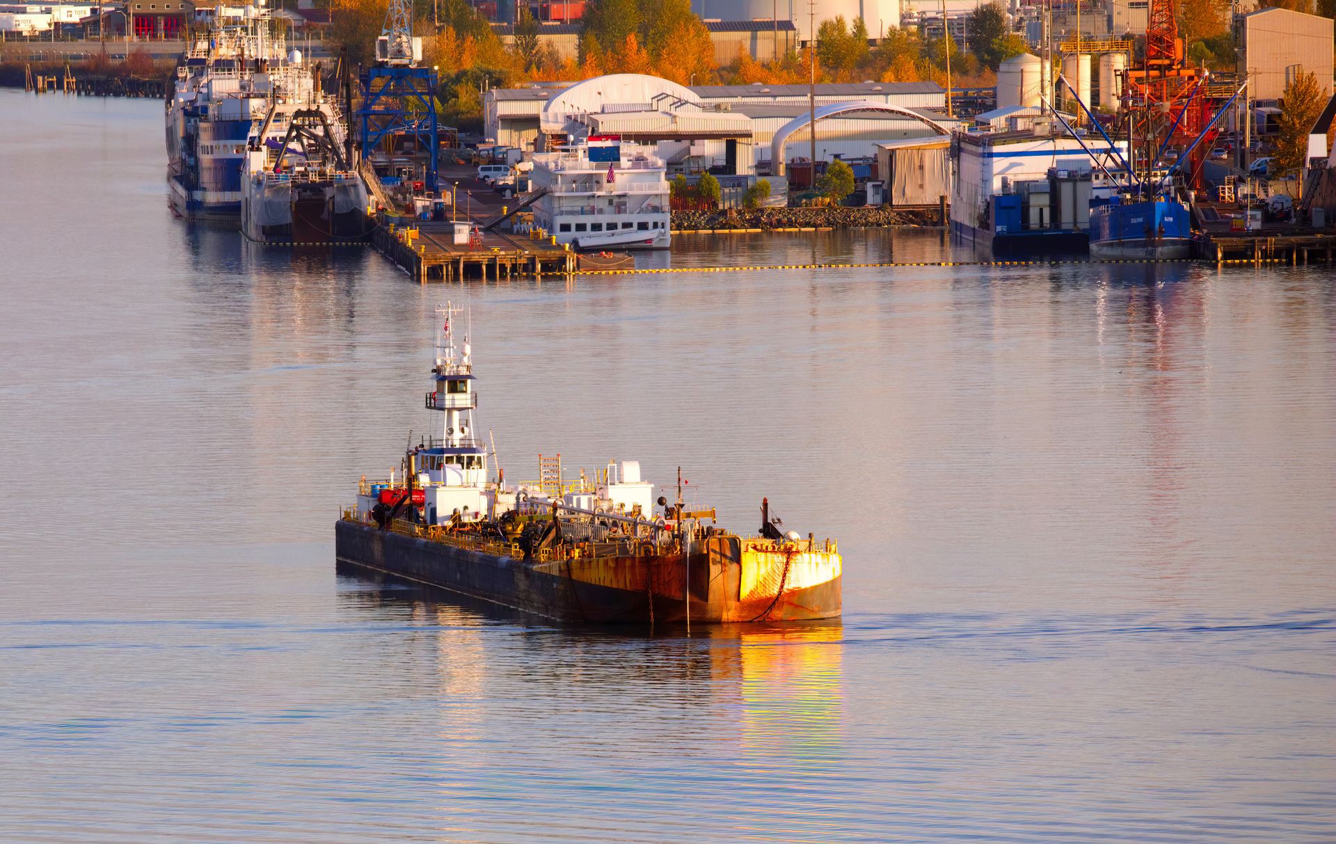 A fuel barge and tug in a harbor at golden hour