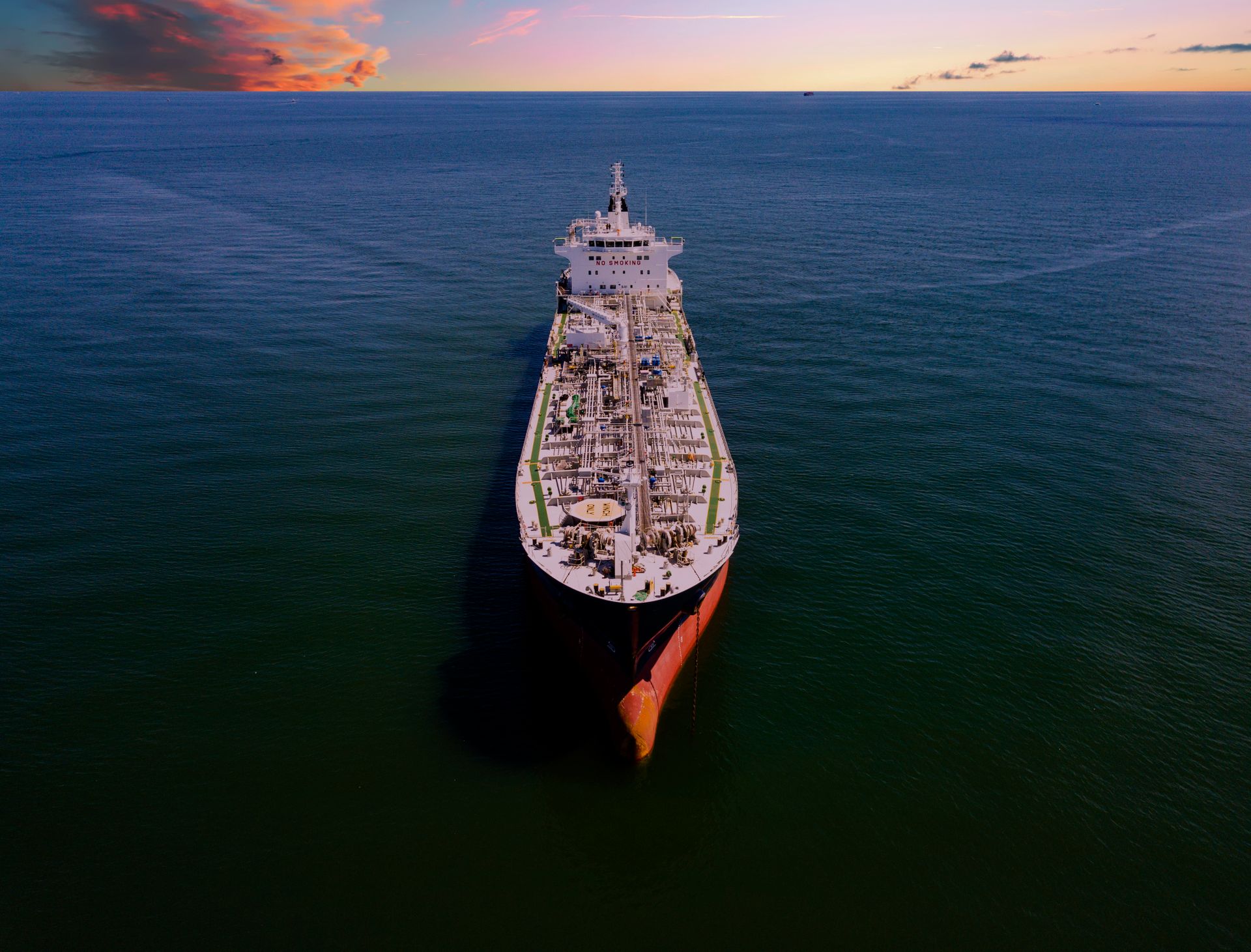An oil tanker at sea at sunset, seen from above