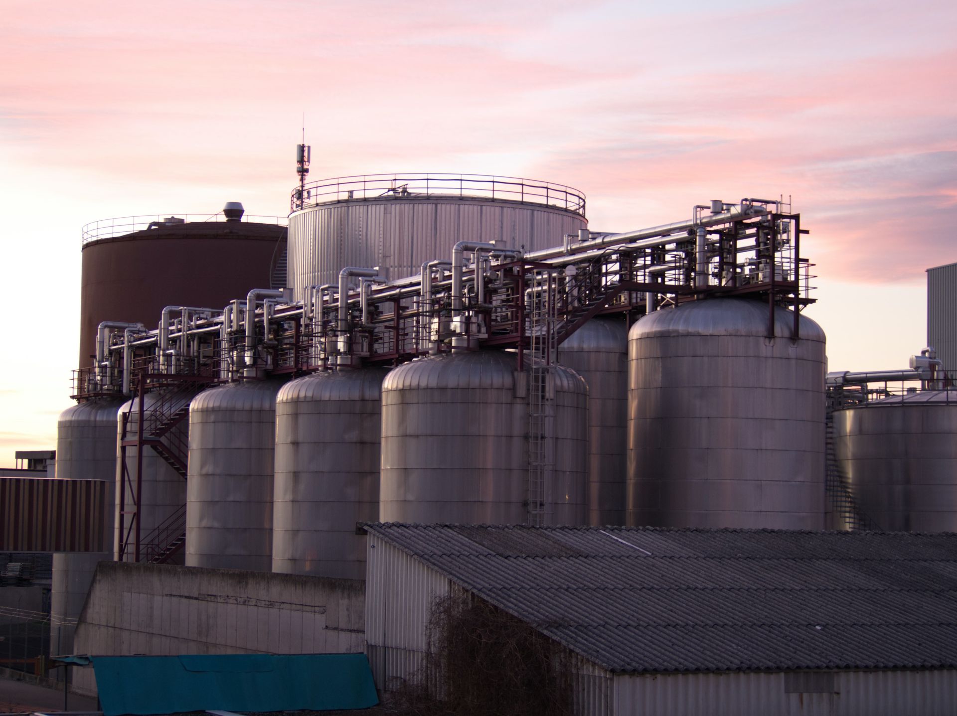 Oil storage tanks and pipework at dusk