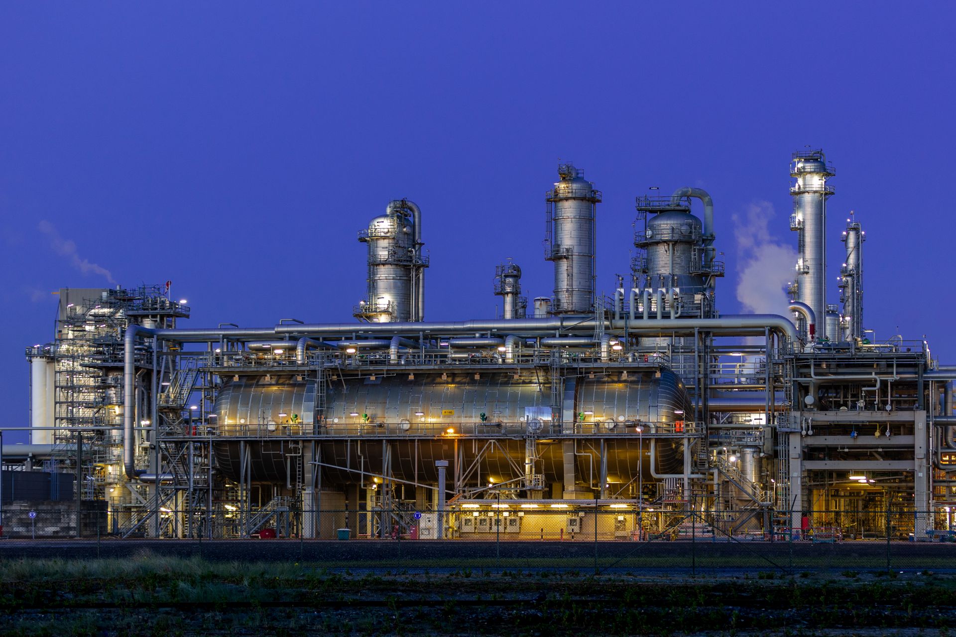 An energy processing facility lit up at dusk