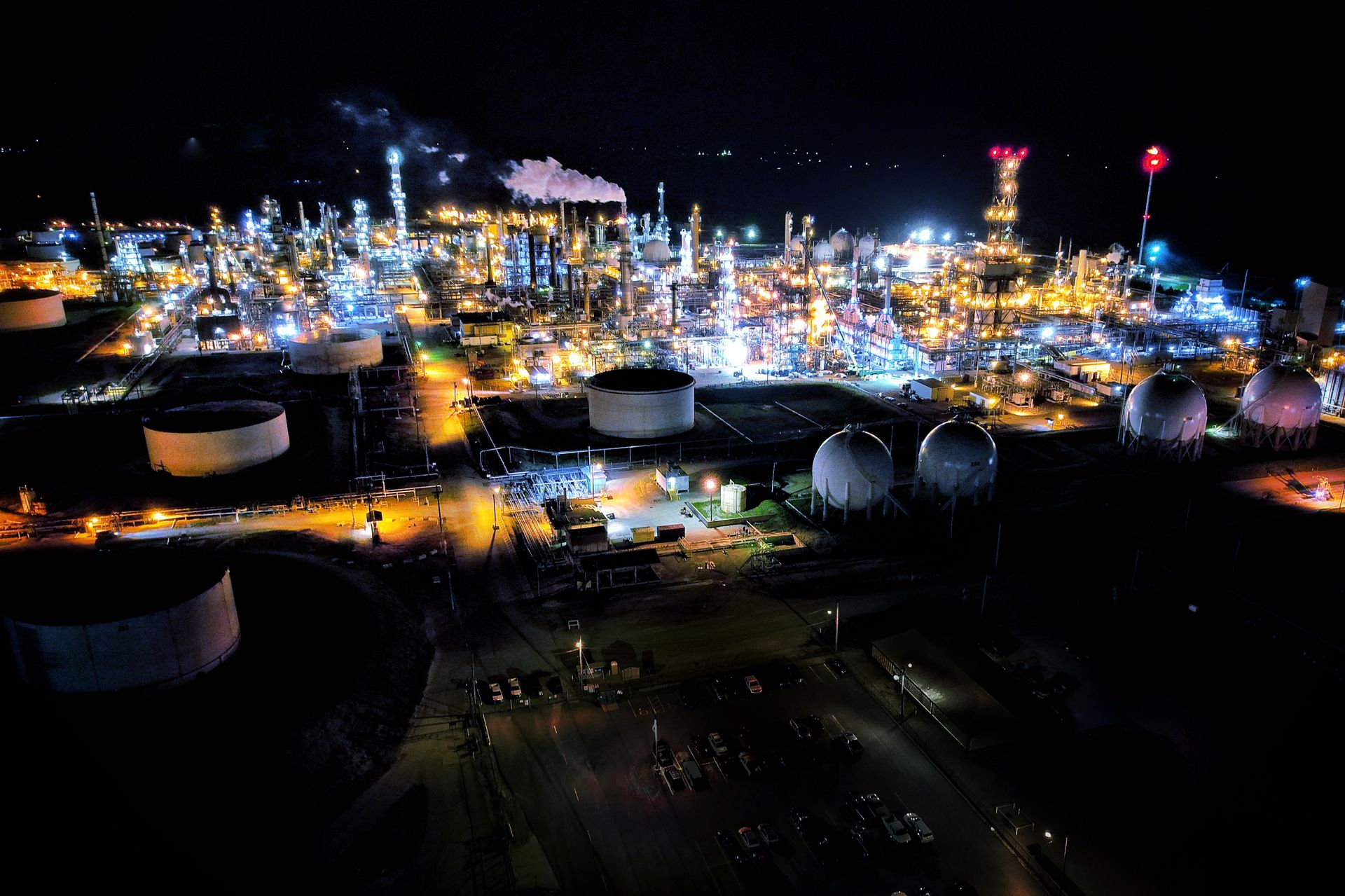 An oil refinery lit up at night, seen from the air